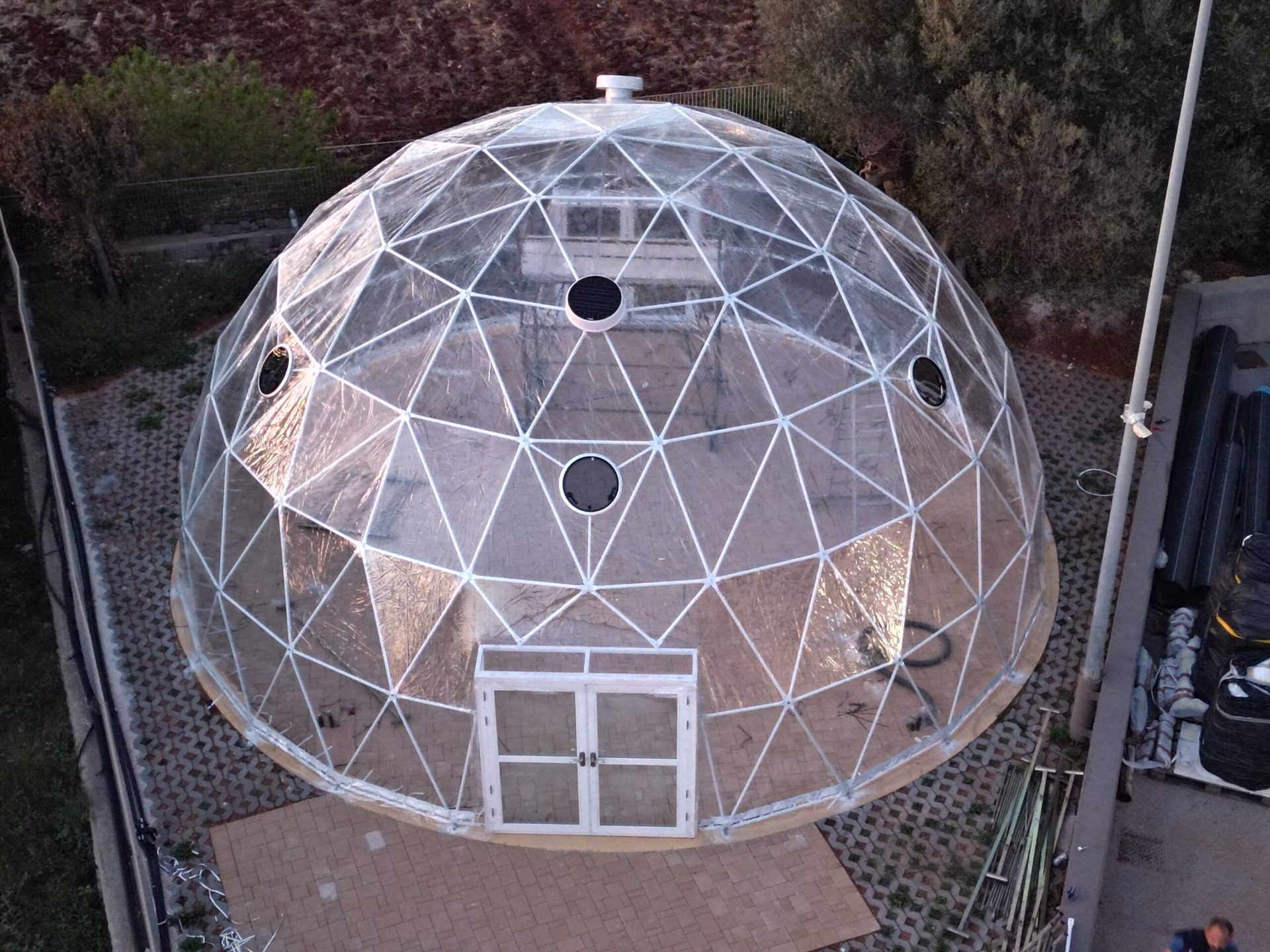 Cupola geodetica trasparente con porta d'ingresso installata in giardino