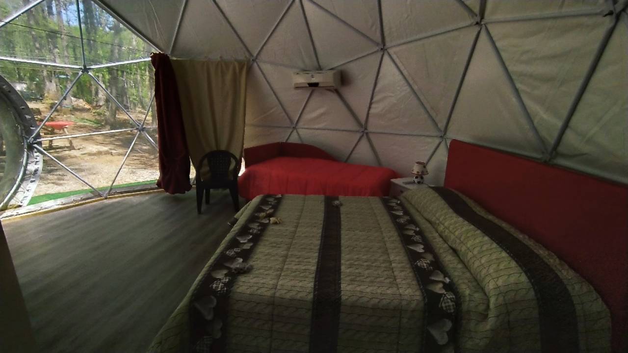 Camera all'interno di una cupola geodetica per glamping