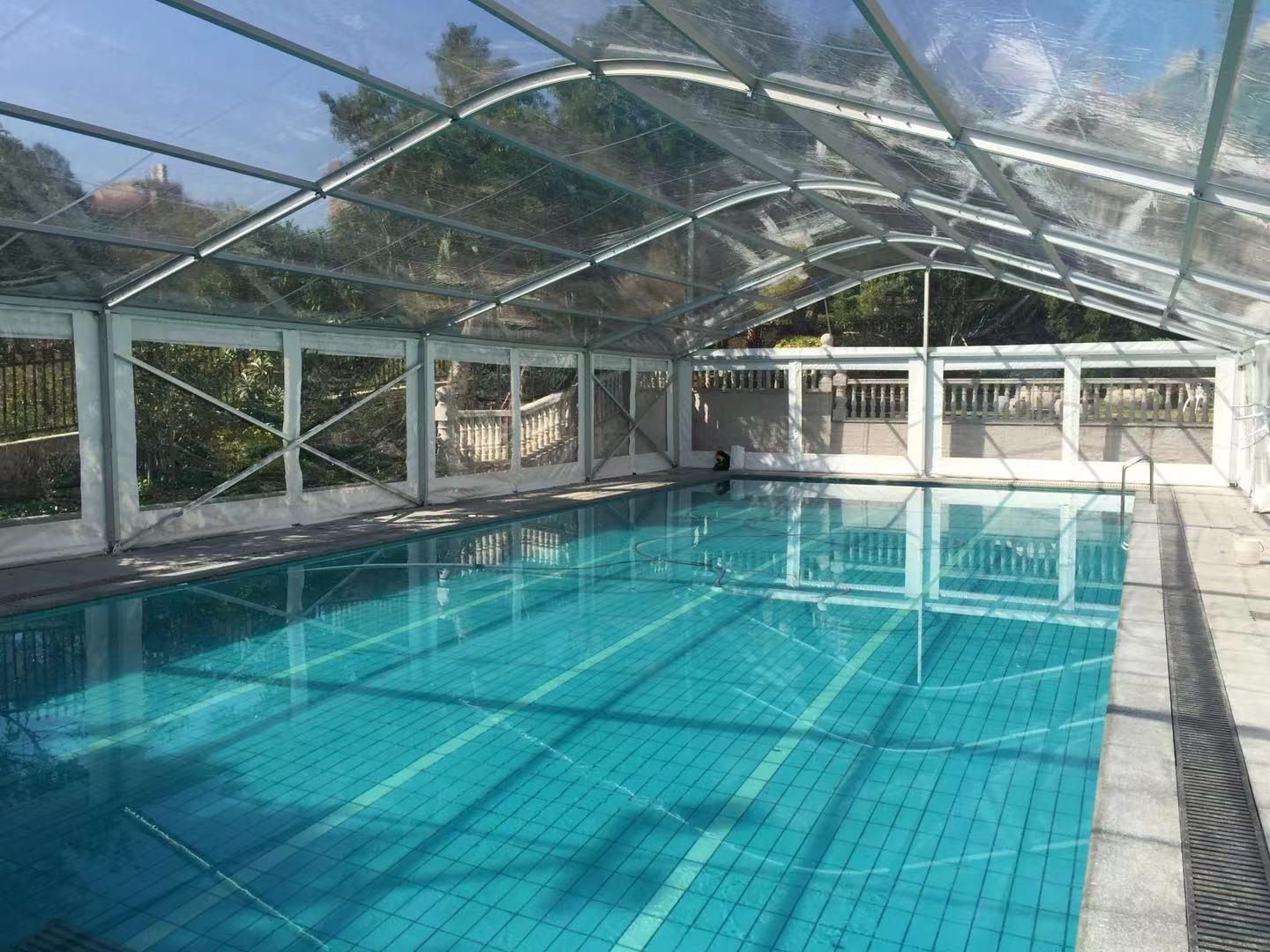 Piscina coperta da una struttura telescopica in vetro e alluminio
