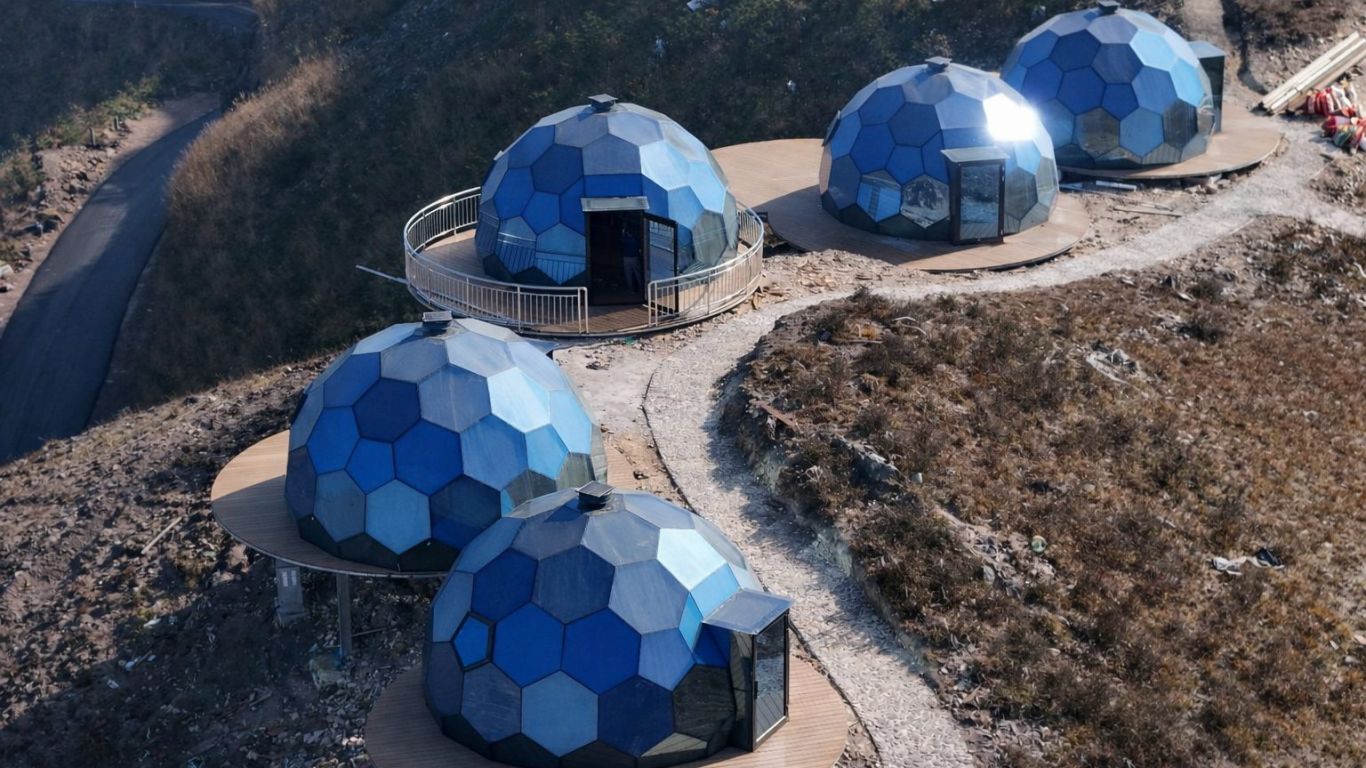 Cupole geodetiche blu installate su una collina
